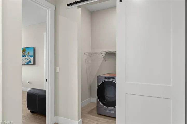 Laundry room with light wood-type flooring and washer / clothes dryer