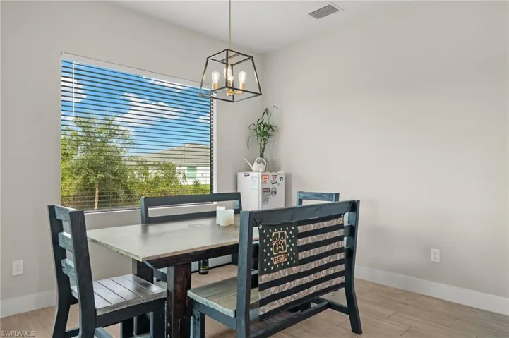 Dining area with an inviting chandelier, light wood-type flooring, and a healthy amount of sunlight