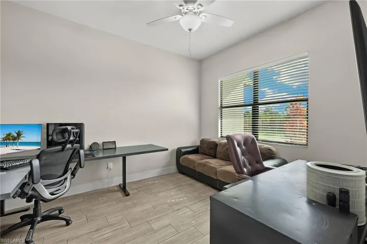 Office area with ceiling fan and light hardwood / wood-style flooring