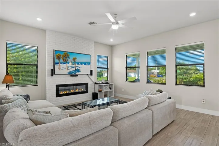 Living room featuring light hardwood / wood-style flooring, ceiling fan, and a fireplace