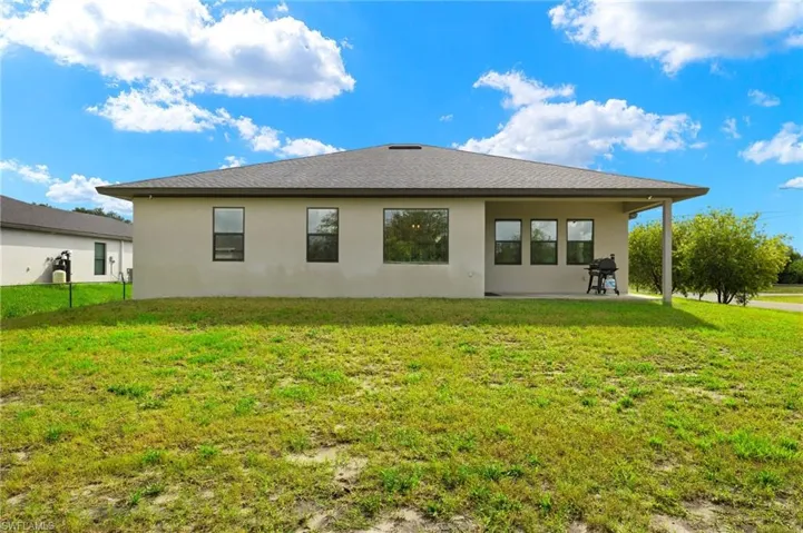 Rear view of property featuring a patio and a yard