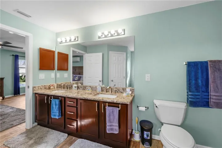 Bathroom featuring ceiling fan, vanity, toilet, and hardwood / wood-style floors