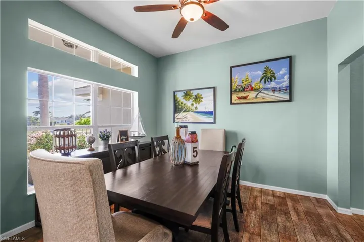 Dining space with dark hardwood / wood-style floors and ceiling fan