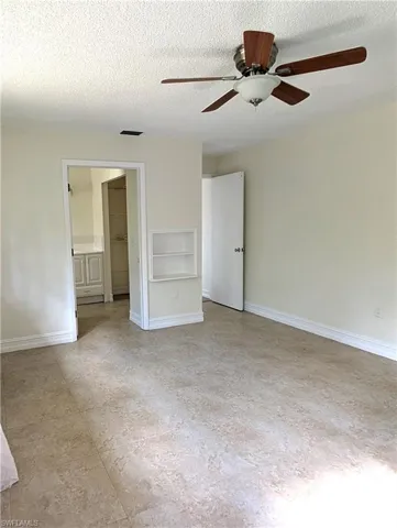 Primary bedroom, ceiling fan, and doorway to the primary bathroom