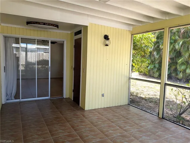screened lanai featuring beamed ceiling, storage closet and a healthy amount of sunlight