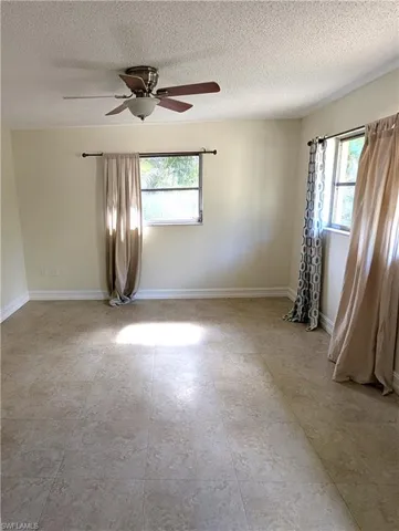 Primary bedroom featuring, tile floor, baseboards and two windows of natural light