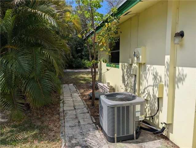 Left side featuring central air condition unit, stucco siding, and side path
