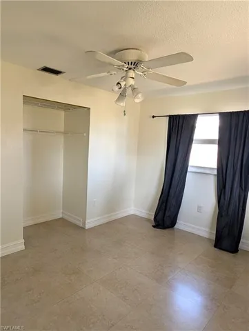 2nd bedroom featuring 2 windows of natural light, a closet, baseboards, and a ceiling fan,