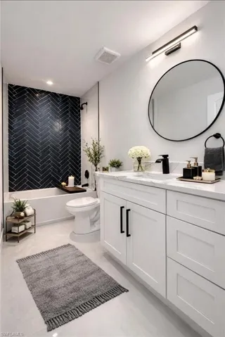 Bathroom with vanity and washtub / shower combination