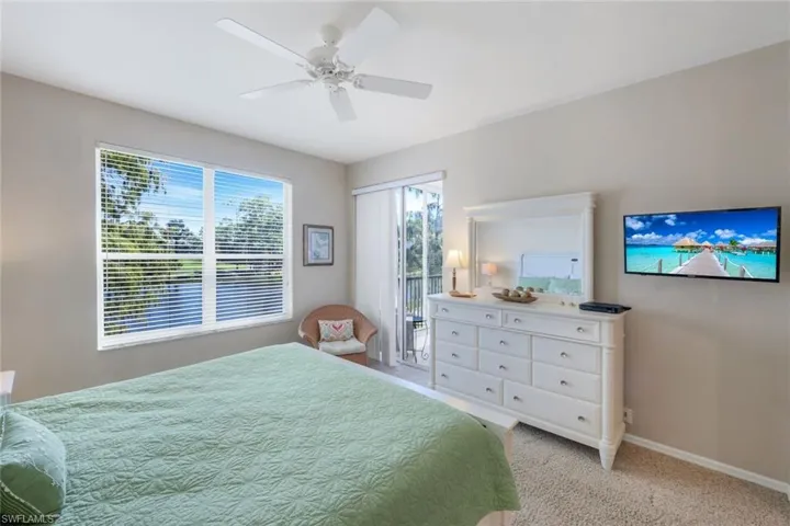 Carpeted bedroom with access to outside and ceiling fan