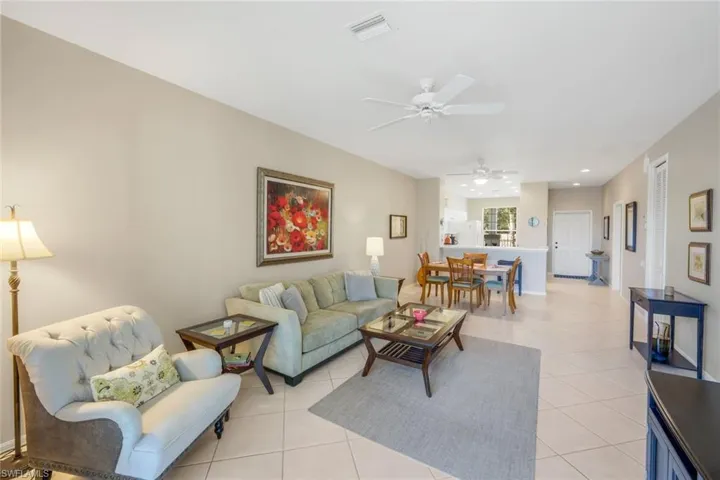 Living area with light tile patterned floors, ceiling fan, and recessed lighting
