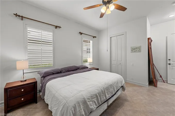 Bedroom featuring a ceiling fan, a closet, and light tile patterned flooring