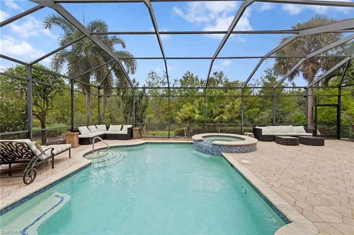View of swimming pool with outdoor lounge area, a sunroom, a patio, a pool with connected hot tub, and glass enclosure