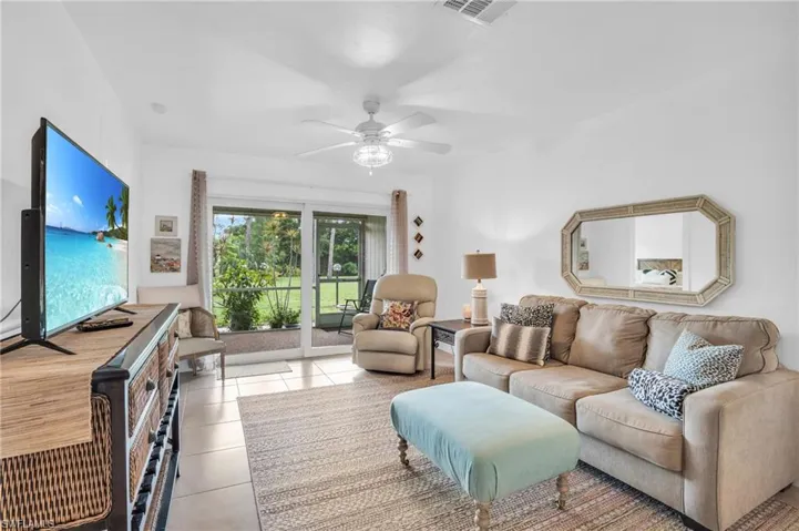 Living room featuring ceiling fan and light tile floors