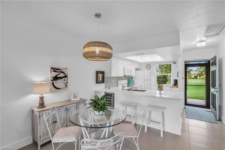 Tiled dining space with sink and wine cooler