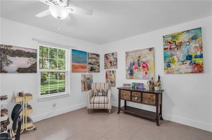 Living area featuring ceiling fan and light tile floors