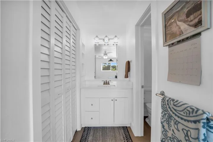 Bathroom featuring vanity with extensive cabinet space and toilet