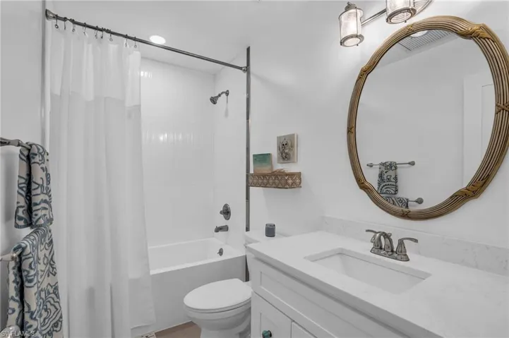 Full bathroom featuring vanity, toilet, and shower / tub combo with curtain