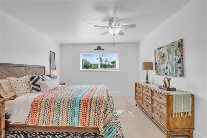Bedroom with ceiling fan and light tile floors