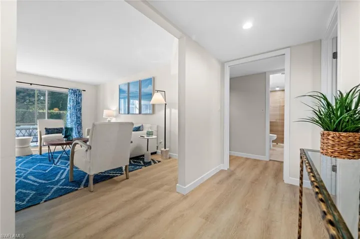 Corridor with light wood-type flooring and baseboards