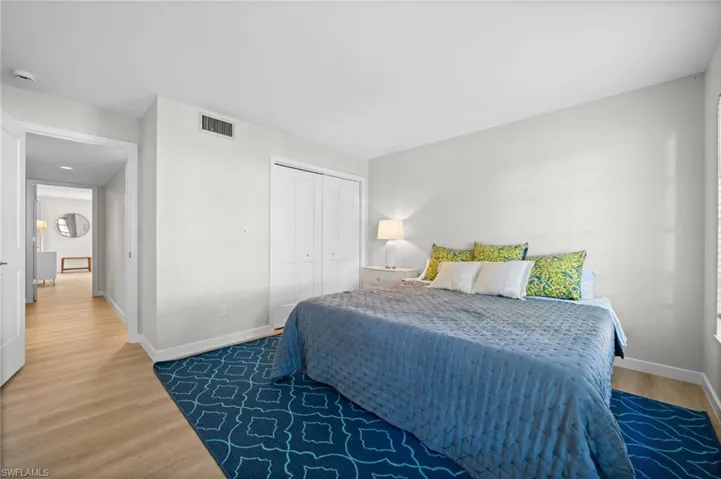Bedroom with wood finished floors and a closet