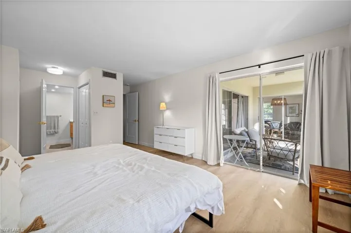 Bedroom featuring wood finished floors, access to outside, a closet, and ensuite bath