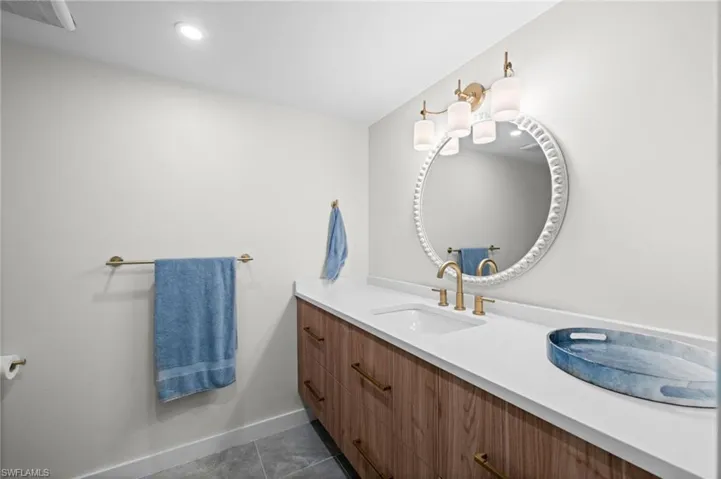 Bathroom featuring vanity, dark tile patterned flooring, and recessed lighting