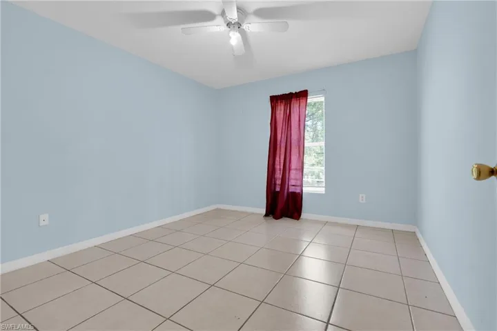 Spacious room with light blue walls and neutral-toned tile flooring