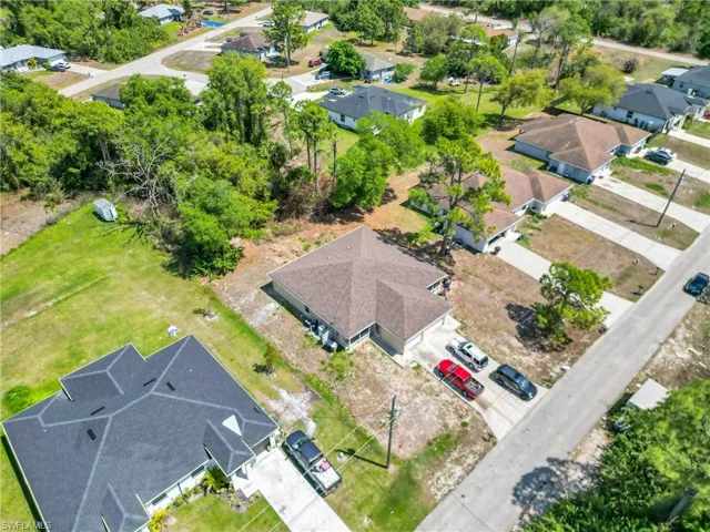 Aerial perspective of a single-family residence featuring a brown shingle roof and a concrete driveway