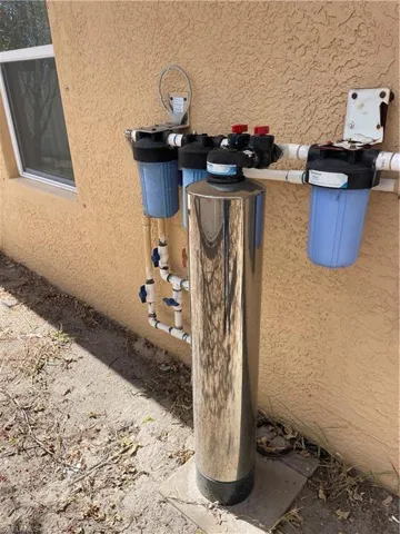 Exterior view of a water softener and stucco siding