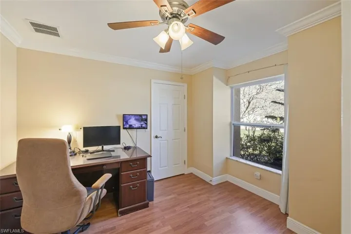 Office space featuring ornamental molding, light wood-type flooring, and ceiling fan