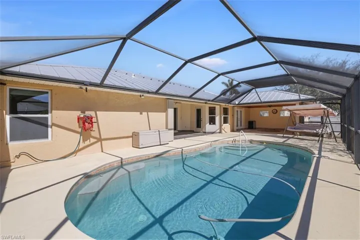 Swimming pool with a lanai, a sunroom, a patio area, and a jacuzzi