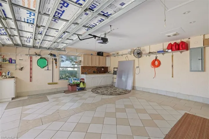 Garage featuring electric panel and a garage door opener