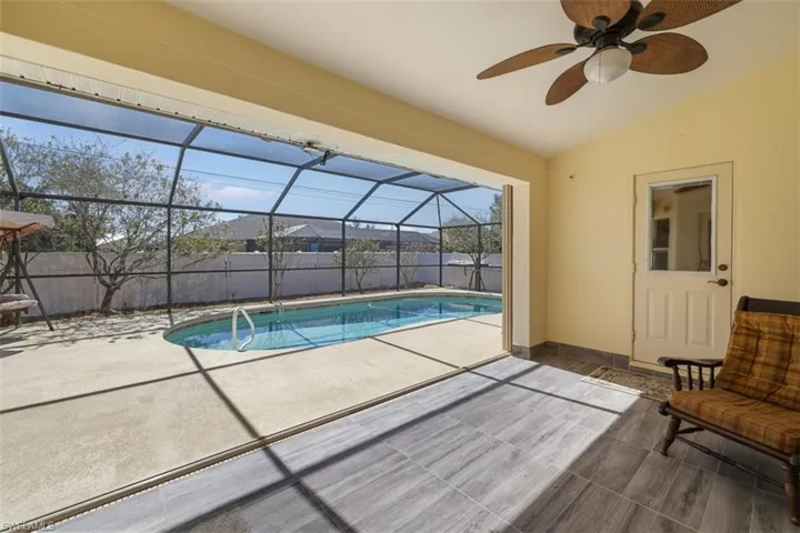 View of swimming pool with a sunroom, a lanai, patio surround, and a fenced backyard