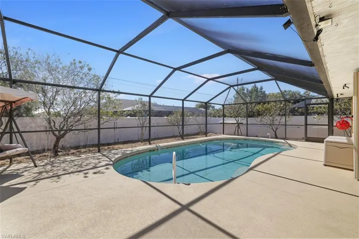 View of swimming pool with a sunroom, glass enclosure, patio surround, and a fenced backyard