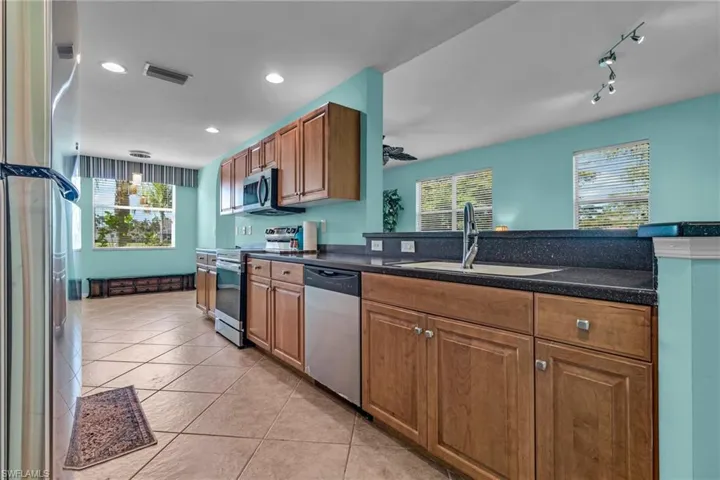 Kitchen featuring sink, a wealth of natural light, light tile floors, and stainless steel appliances