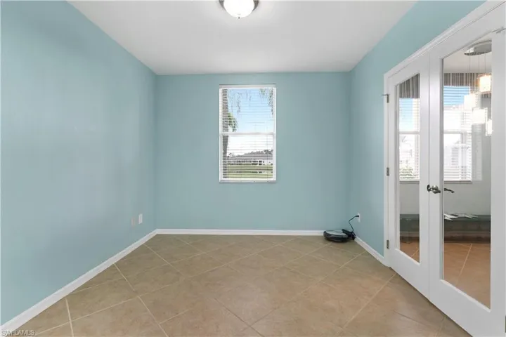 Tiled spare room with french doors