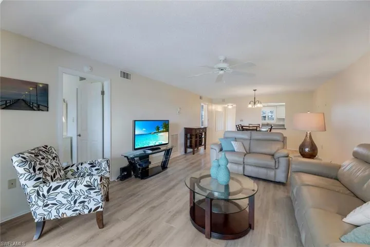 Living room with ceiling fan and light wood-type flooring