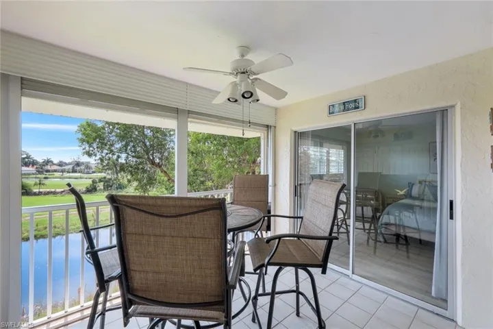Sunroom / solarium with a water view, ceiling fan, and a healthy amount of sunlight