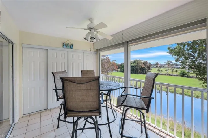 Sunroom / solarium featuring a water view and ceiling fan