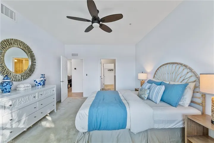 Bedroom featuring ceiling fan, ensuite bath, and light colored carpet