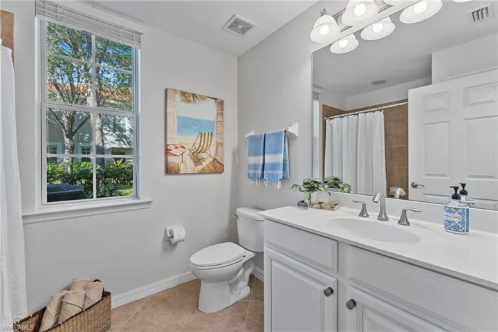 Full bath with vanity, a shower with shower curtain, and light tile patterned flooring