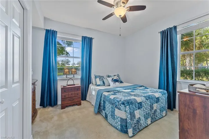 Bedroom with a ceiling fan and light colored carpet