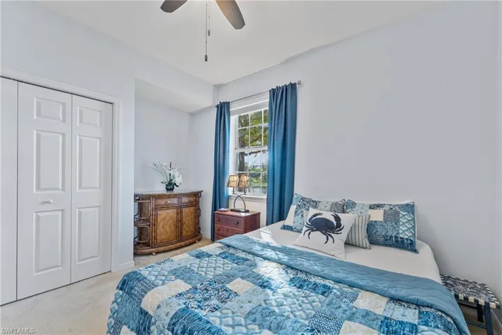 Bedroom featuring a closet, light carpet, and a ceiling fan