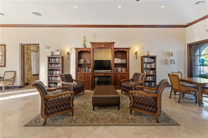 Living room with ornamental molding, recessed lighting, and a fireplace