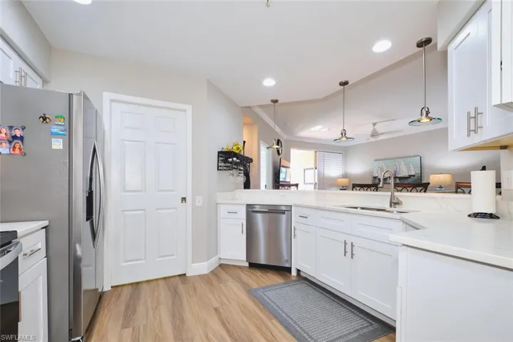 Kitchen featuring white cabinets, hanging light fixtures, stainless steel appliances, recessed lighting, and crown molding