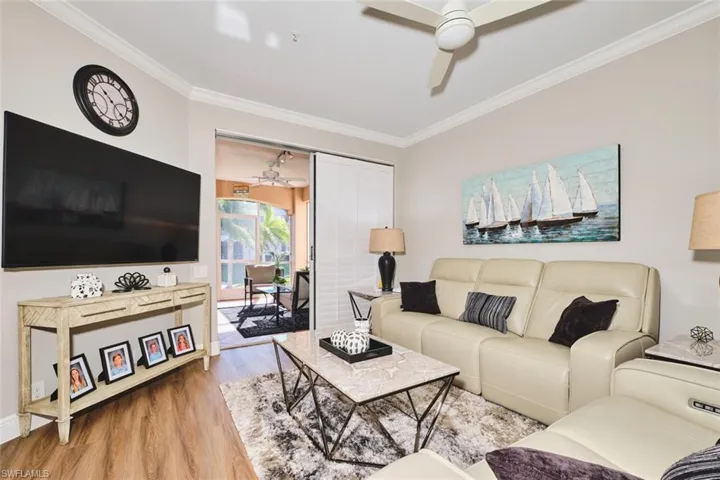 Living area featuring wood finished floors, crown molding, and ceiling fan