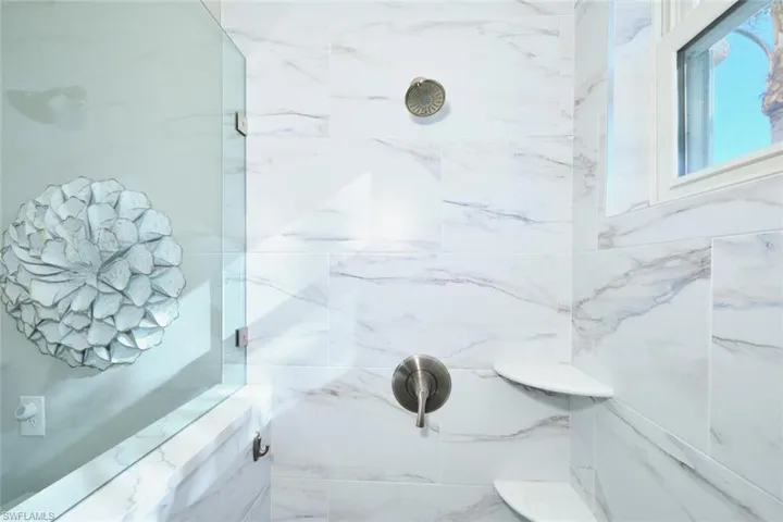 Full bath featuring a marble finish shower