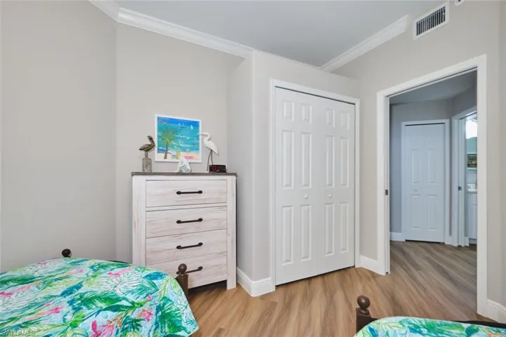 Bedroom featuring ornamental molding, a closet, and light wood finished floors