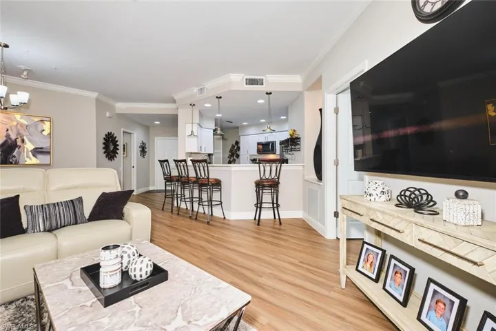 Living area with light wood-style floors and crown molding